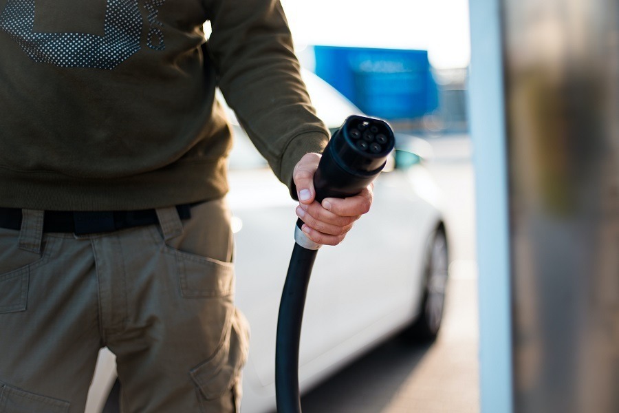 Ein Mann hält ein Ladekabel für ein Elektroauto in der Hand. Carano bietet digitale Lösungen für Unternehmen, um Elektromobilität effizient in den Fuhrpark zu integrieren. Mit moderner Software wird das Management von Ladevorgängen, Fahrzeugen und Stromkosten einfach, nachhaltig und wirtschaftlich gesteuert.