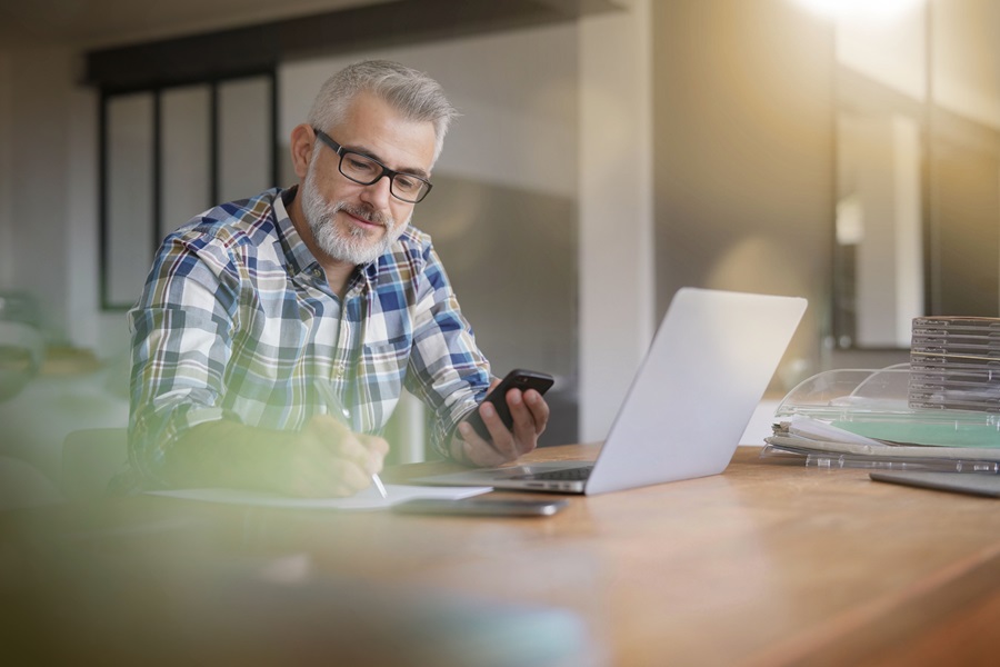 Een man zit aan zijn bureau te werken met een smartphone, laptop en documenten. Voor het wagenparkbeheer is het van cruciaal belang dat alle voertuigkosten worden geregistreerd. Carano biedt digitale oplossingen voor de analyse van de Total Cost of Ownership – voor maximale kostentransparantie, weloverwogen beslissingen en een economisch geoptimaliseerd wagenparkbeheer.