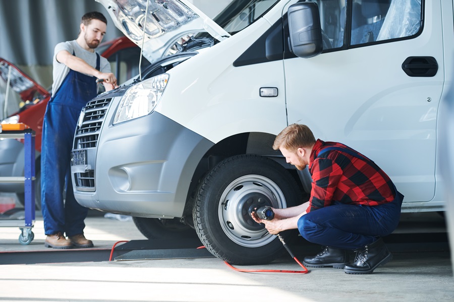 Twee medewerkers inspecteren een bedrijfsvoertuig: de ene bij de band, de andere onder de geopende motorkap. Deze scène illustreert de UVV-voertuigkeuring volgens DGUV-voorschrift 70. Carano biedt digitale oplossingen voor een volledige documentatie en juridisch verantwoorde uitvoering van deze keuringsverplichtingen binnen het wagenparkbeheer – voor meer veiligheid en efficiëntie. 