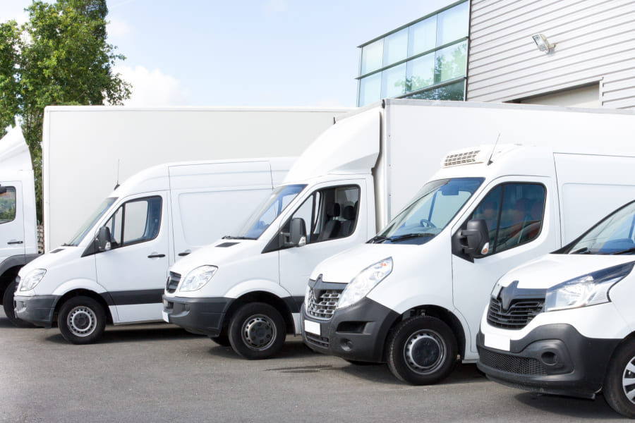 Eine Reihe moderner Transporter zeigt eine typische Unternehmensflotte. Das Motiv verdeutlicht, wie ein Flottenmanagementsystem Unternehmen bei effizienter Planung und digitaler Fuhrparksteuerung unterstützt.