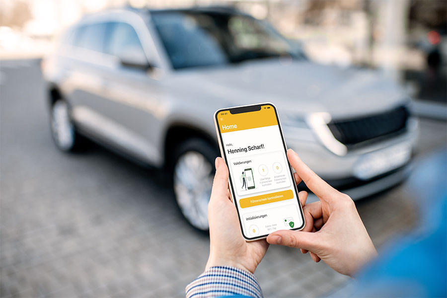Person nutzt Smartphone-App zur elektronischen Führerscheinkontrolle vor einem Firmenfahrzeug. Die digitale Lösung von CarWise ermöglicht eine zentrale, revisionssichere Dokumentation und unterstützt transparentes Fuhrparkmanagement bei vielen Fahrern und Standorten.